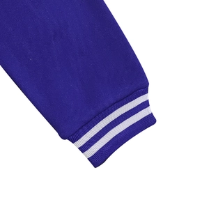 Detail of navy blue fleece jacket sleeve with striped ribbed cuffs and premium knit texture