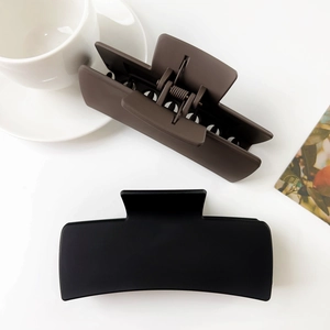 Flat lay of vintage matte square hair claws in brown and black on a white table
