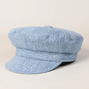 Close-up of light blue denim newsboy hat showing texture and button detail
