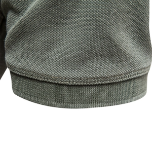 Short sleeve cotton polo shirt in sage green showing piqué fabric texture and ribbed cuff