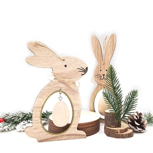 Detail of wooden Easter bunny ornaments with jute bows and egg pendant on white background