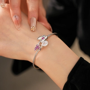 Detail of pink zircon butterfly cuff with sparkling pear-cut stone and pavé setting