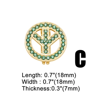 Makro-Detail eines 18mm vergoldeten Friedenszeichens mit grünen Zirkoniasteinen