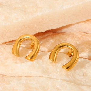 Macro shot of 18K gold plated U-shaped stud earrings on natural crystal background