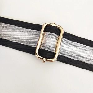 Detail of adjustable 3.8cm striped nylon bag strap with polished gold metal buckle