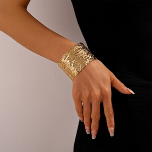 Detailed view of wide gold cuff bracelet featuring textured lava finish on model