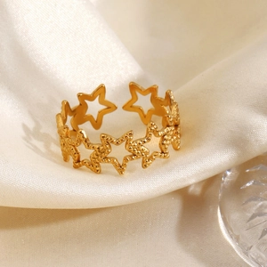 Minimalistischer goldener Stern-Ausschnitt-Ring mit Textur auf beigem Seidenstoff