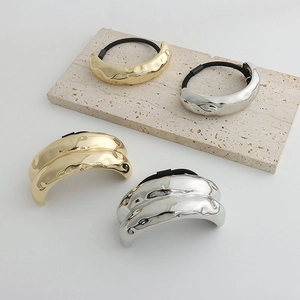 Detailed view of gold and silver metallic crinkle hair ties with wavy texture