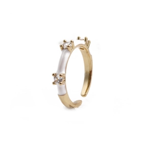 Close-up of adjustable gold-plated ring with white enamel and three small zircons