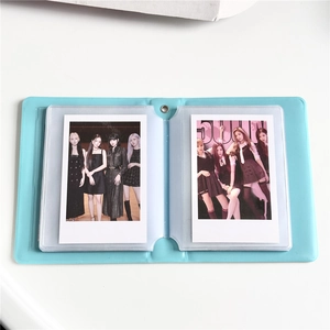 Detail view of open light blue photocard album with transparent plastic inner sleeves