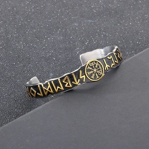Detail of Viking cuff bracelet featuring golden Vegvisir compass and Nordic runes