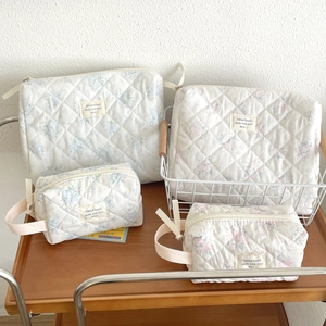 Detailed macro view of quilted floral cotton makeup bag with a durable fabric handle
