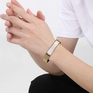 Macro detail of gold-plated mesh strap bracelet with a sparkling crystal-set bar