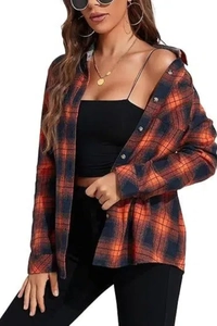 Detailed view of the buttoned cuffs and woven flannel plaid texture on this orange shirt