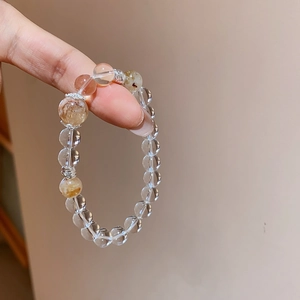 Détails des perles de cristal blanc et quartz rutilé doré sur un bracelet élégant
