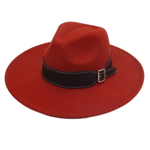 Macro detail of red wool felt fedora featuring a black leather band and silver buckle