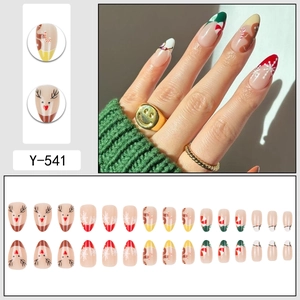 Almond-shaped Christmas press-on nails featuring reindeer, gingerbread man, and snowflake designs