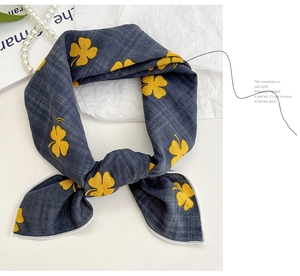 Detail of navy blue cotton linen floral scarf with white hem and clover pattern
