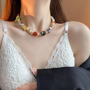 Detailed view of colorful ceramic beads and gold twisted accents on a retro ethnic necklace