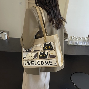 Beige canvas tote bag with cute cat illustration and Welcome text for daily casual style