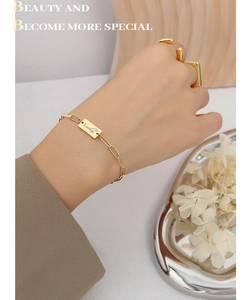 Vista dettagliata del bracciale Lucky placcato oro 18 carati e anelli coordinati sulla mano