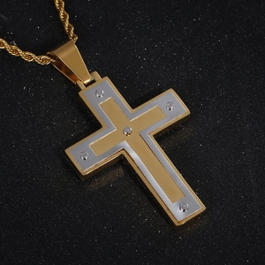 Détail du pendentif croix bicolore or et argent avec vis sur une chaîne torsadée