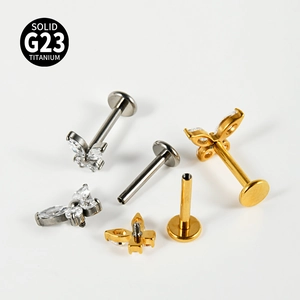 Detail of G23 titanium labret studs featuring zircon butterfly design and flat back post