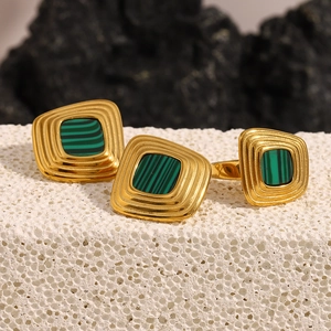 Close-up of 18K gold plated geometric ring and earrings set with green malachite inlay