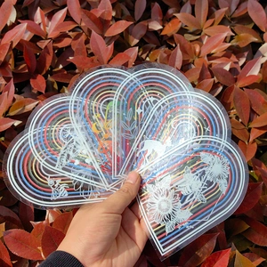 Rainbow suncatcher window stickers with heart shapes and nature patterns on red background