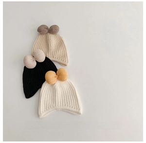 Detailed view of three rib-knit baby hats featuring contrasting oversized bows