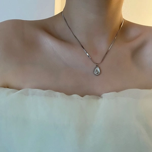 Silver avocado shell pendant necklace in titanium steel on a female model