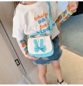 Close-up of quilted PU leather girl's purse with cute rabbit ears and bow decoration