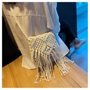 Detail of bohemian macrame crossbody bag featuring fringe tassels and geometric weave
