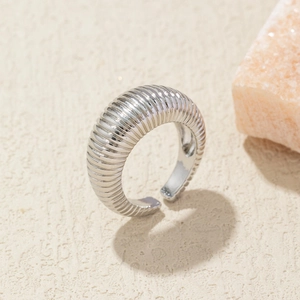 Detail of silver croissant dome ring with textured vertical stripes and open band design