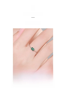 Detail of minimalist S925 sterling silver chain ring with emerald cut green zircon