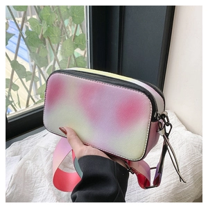 Detail of colorful gradient camera bag with cross-grain texture and wide shoulder strap