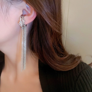 Detail of silver long chain tassel ear cuff with sparkling cubic zirconia on model