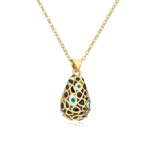 Macro detail of 18K gold plated teardrop pendant with blue evil eye enamel motifs