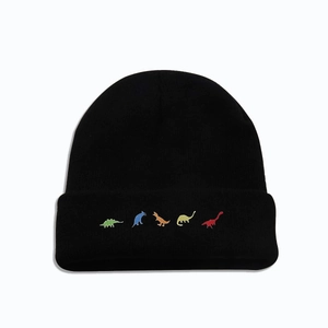 Detail der bunten Dinosaurier-Stickerei am Umschlag einer schwarzen Strickmütze