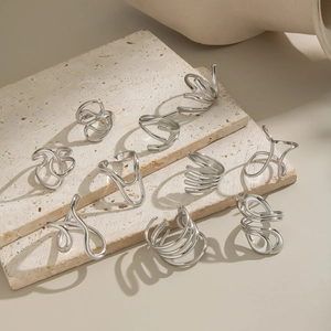 Set of minimalist silver geometric rings featuring abstract linear and spiral designs
