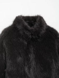 Close-up detail of luxury black faux fur coat showing soft texture and stand collar