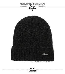 Detail view of thick knitted beanie showing chenille texture and silver metal logo