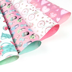 Pastel gift wrapping paper featuring heart, bicycle, and floral patterns on white background
