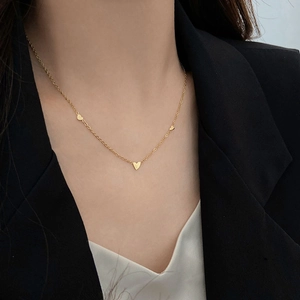 Minimalist 18K gold plated titanium necklace with small heart charms on model