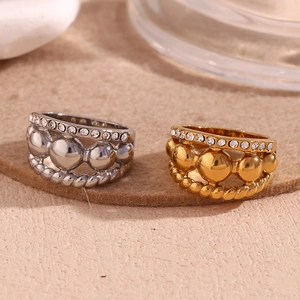 Detail of 18K gold and silver stacked rings with triple beads, rope texture, and rhinestones