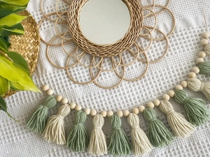Bohemian rattan flower mirror detail with green and beige wood bead tassel accents