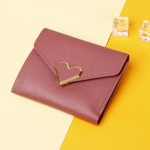 Detailed macro view of pink PU leather wallet with a heart-shaped gold metal buckle