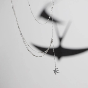 Détail du collier multi-rangs hirondelle en acier titane argenté avec ombre artistique