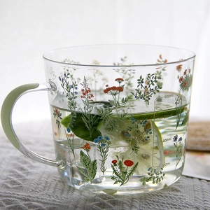 Ins style heat-resistant glass mug with floral pattern, green handle, and 400ml scale