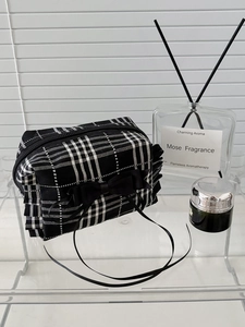 Trousse à maquillage à carreaux noir et blanc avec nœud et bords volantés sur étagère